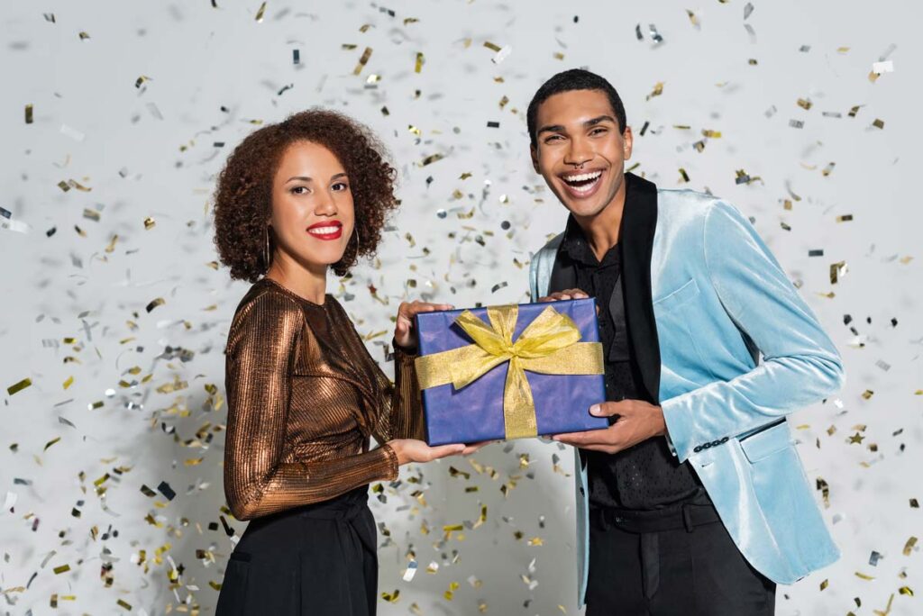 Two people holding a prize with confetti