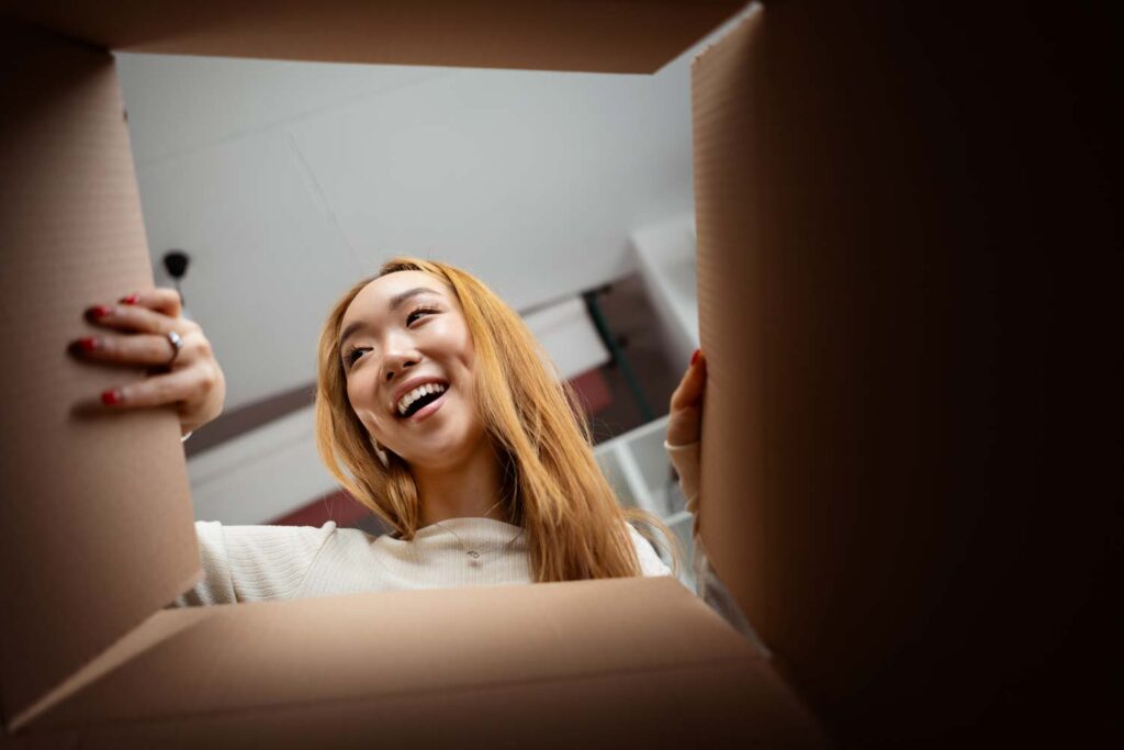Lady opening a cardboard box to find her prize