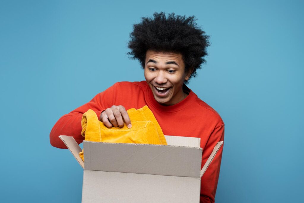 A man taking a prize out of a box - possibly a yellow jumper